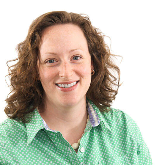 Individual in a green polka dot shirt, smiling against a white backdrop.