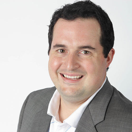 A person in a gray suit smiling, featured in business consulting context by TiER1.