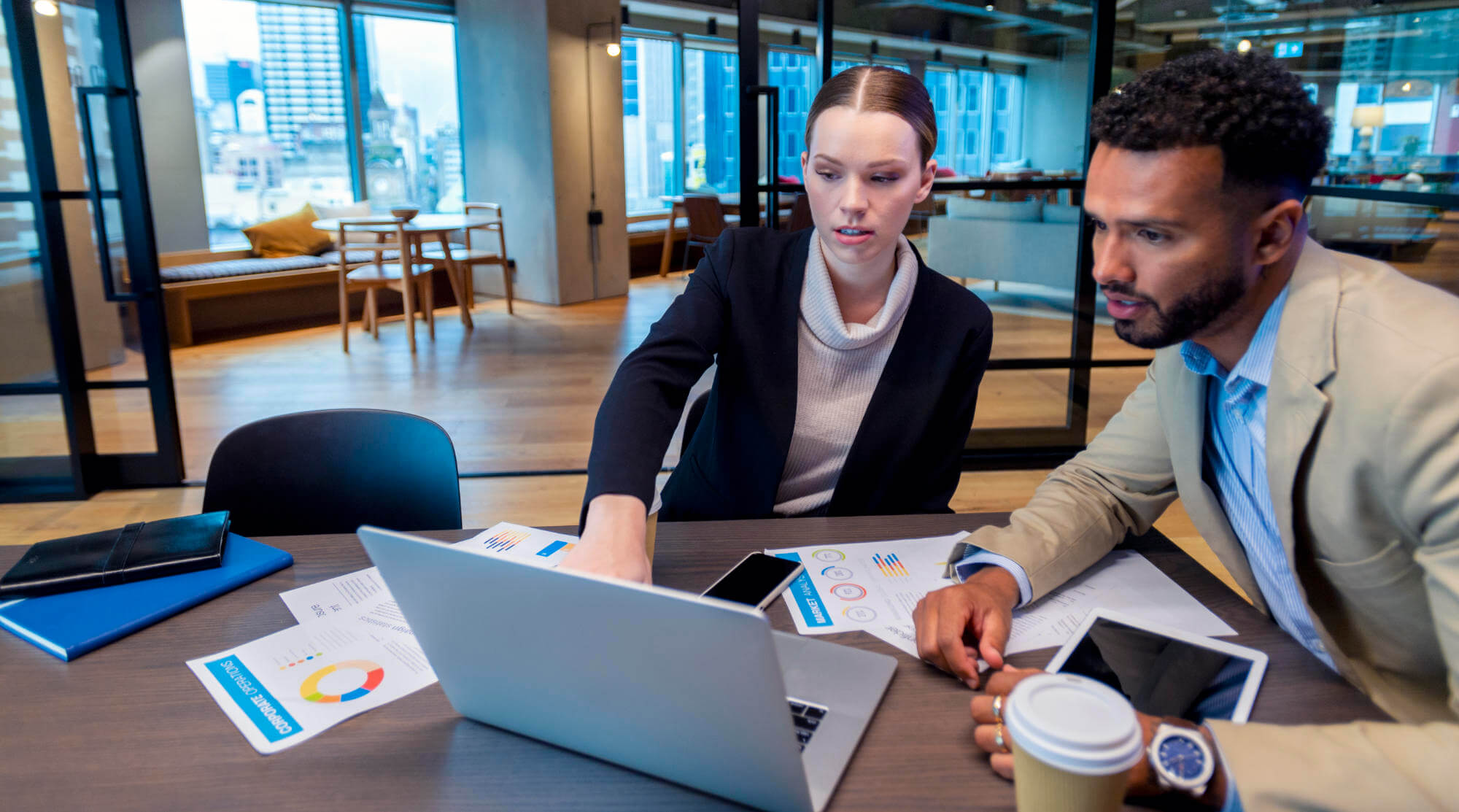 Two colleagues reviewing data on a laptop at a conference table