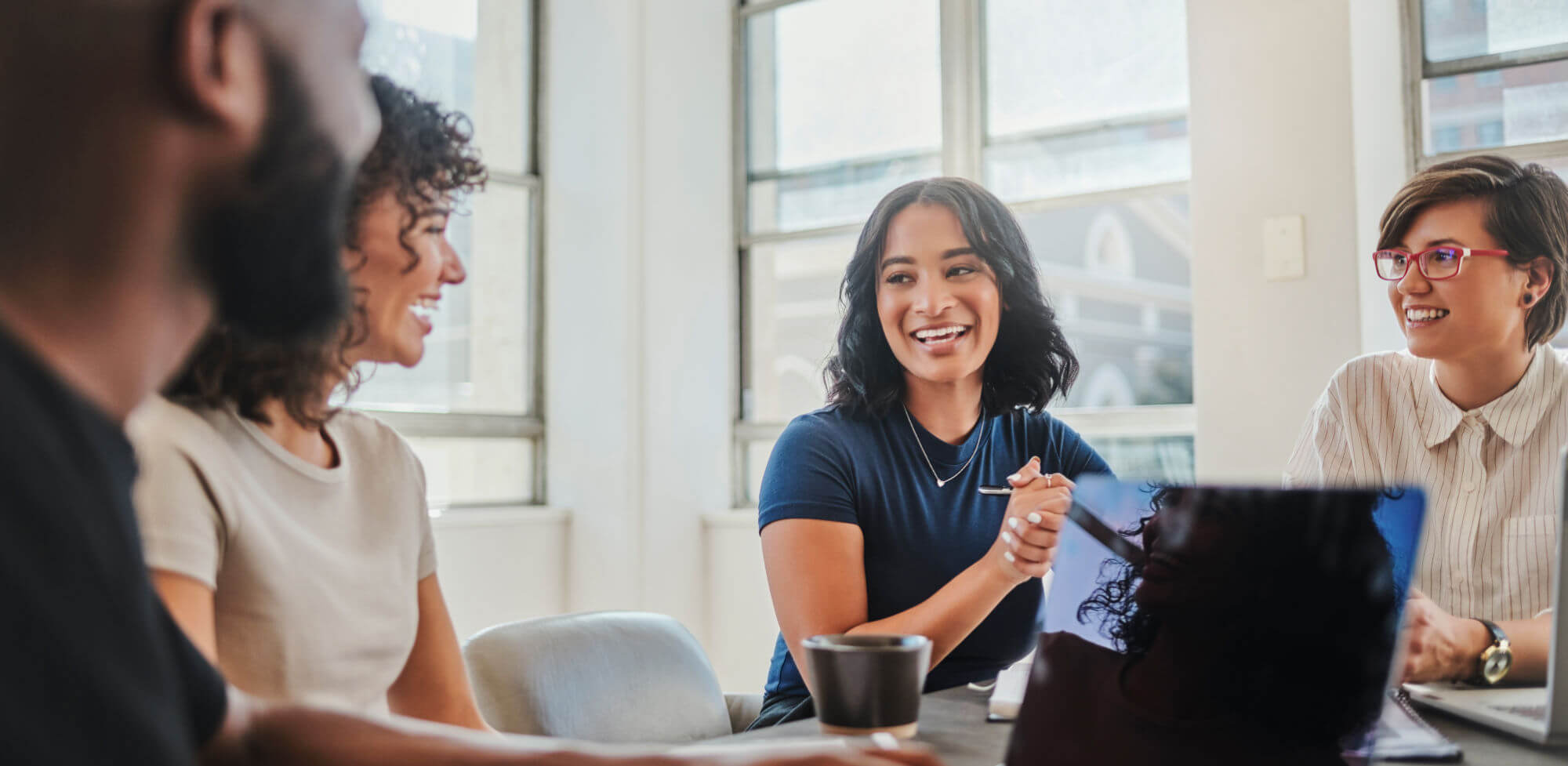 Business meeting, global company and teamwork diversity with laptop, black man and women in South African office. Smile, happy or creative people in communication, collaboration and strategy planning