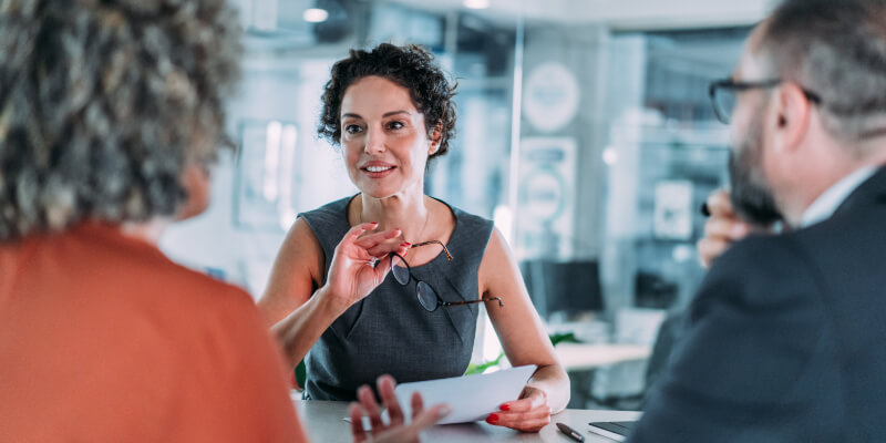 Shot of group of business persons in business meeting. Three entrepreneurs on meeting in board room. Corporate business team on meeting in modern office. Female manager discussing new project with her colleagues. Company owner on a meeting with two of her employees in her office.