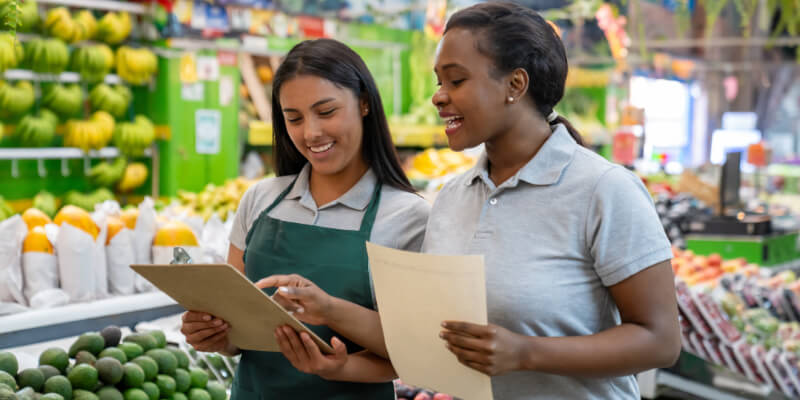 Retail clerk training a new employee at the supermarket.