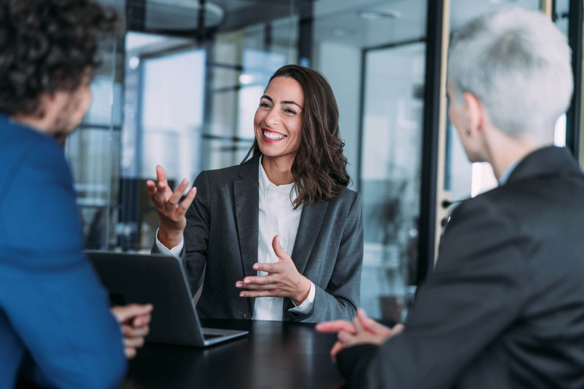Shot of group of business persons in business meeting. Three entrepreneurs on meeting in board room. Corporate business team on meeting in modern office. Female manager discussing new project with her colleagues. Company owner on a meeting with two of her employees in her office.