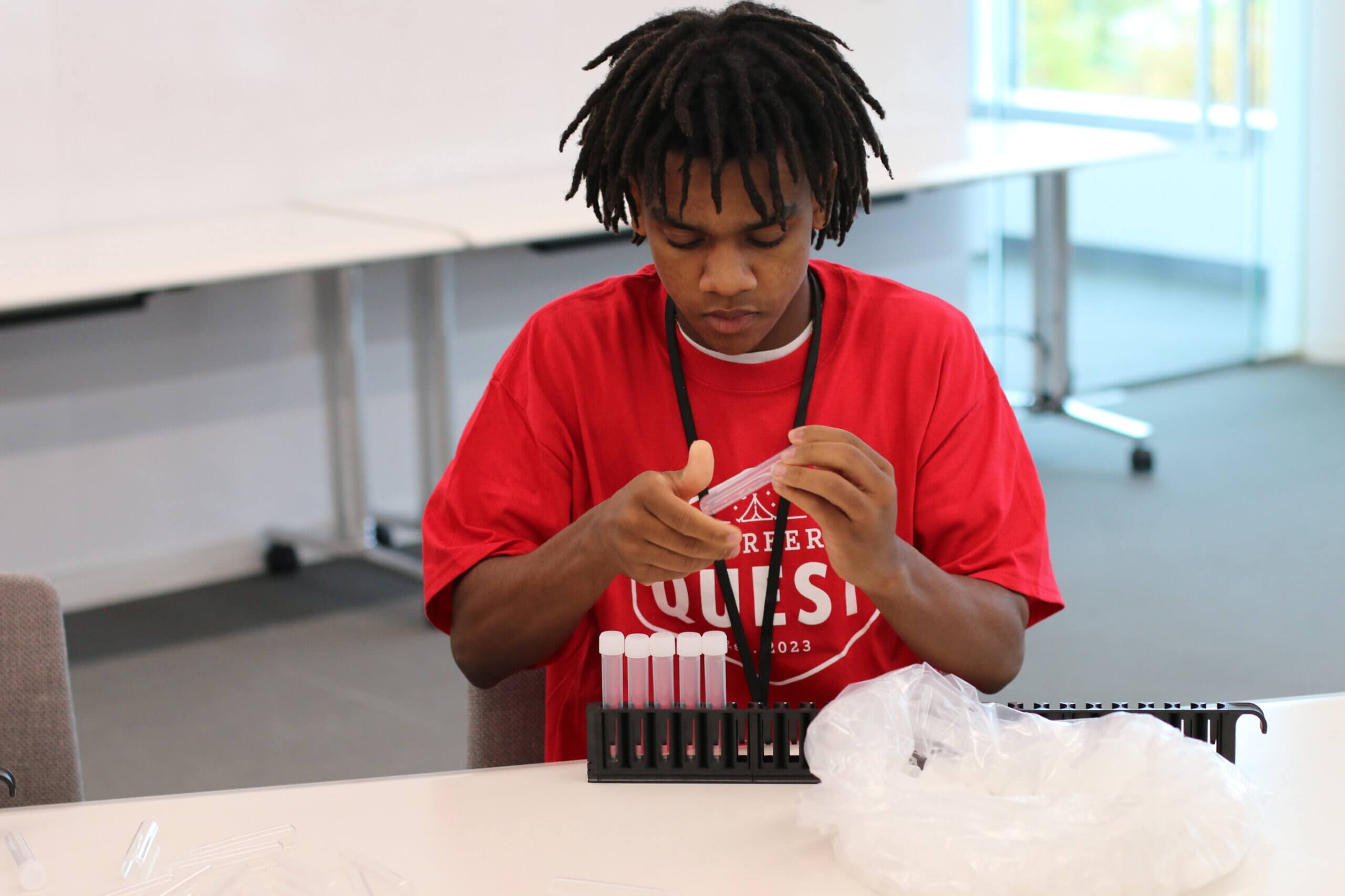 A student participates in a capping tubes challenge at the 2024 October Career Quest event.