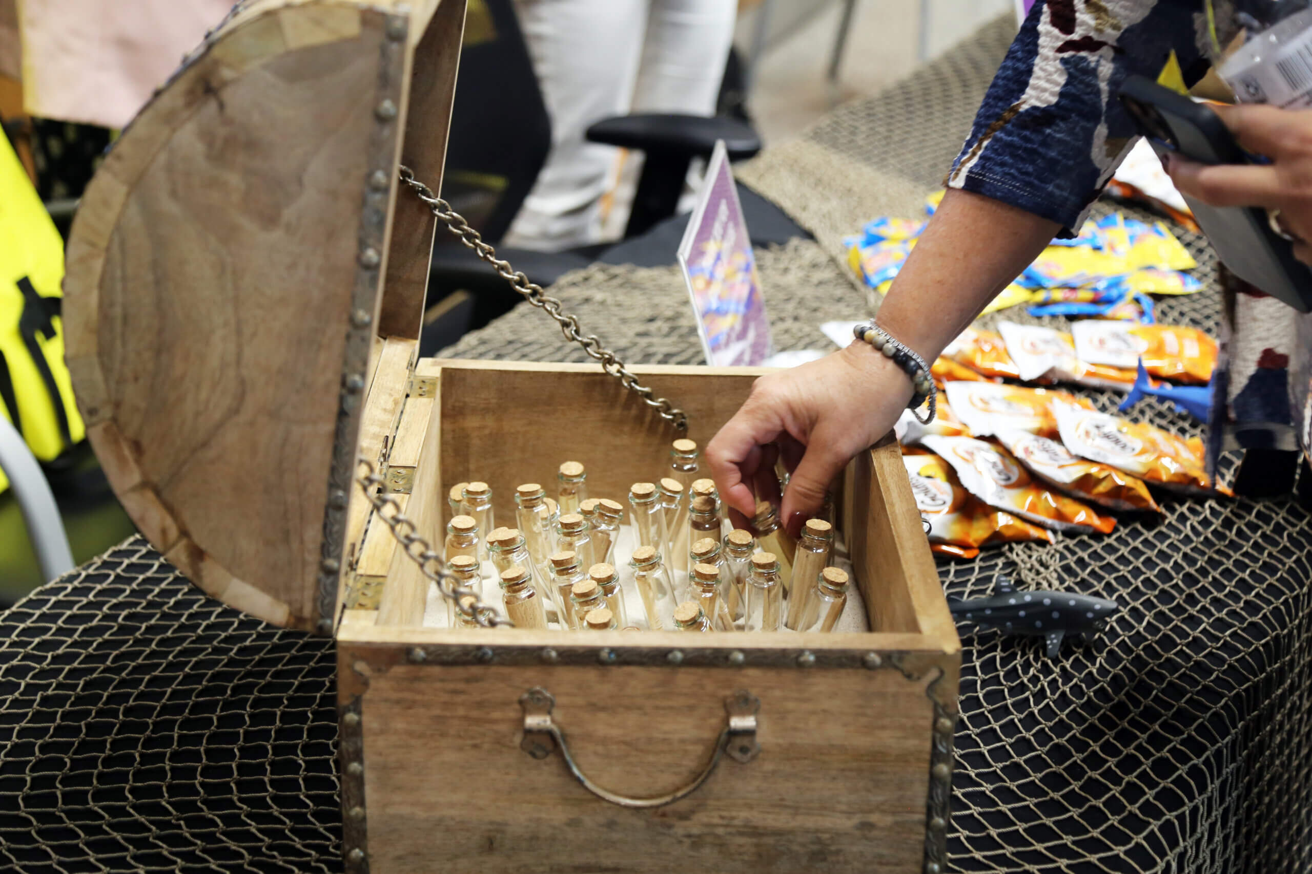 A person reaching into a treasure chest to pull out a message in a bottle.