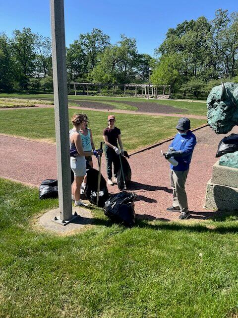 People volunteering and picking up trash in a park.