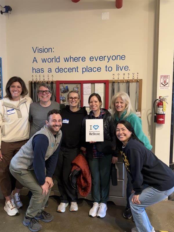 A group of people posing for a picture when volunteering at Habitat for Humanity's ReStore.