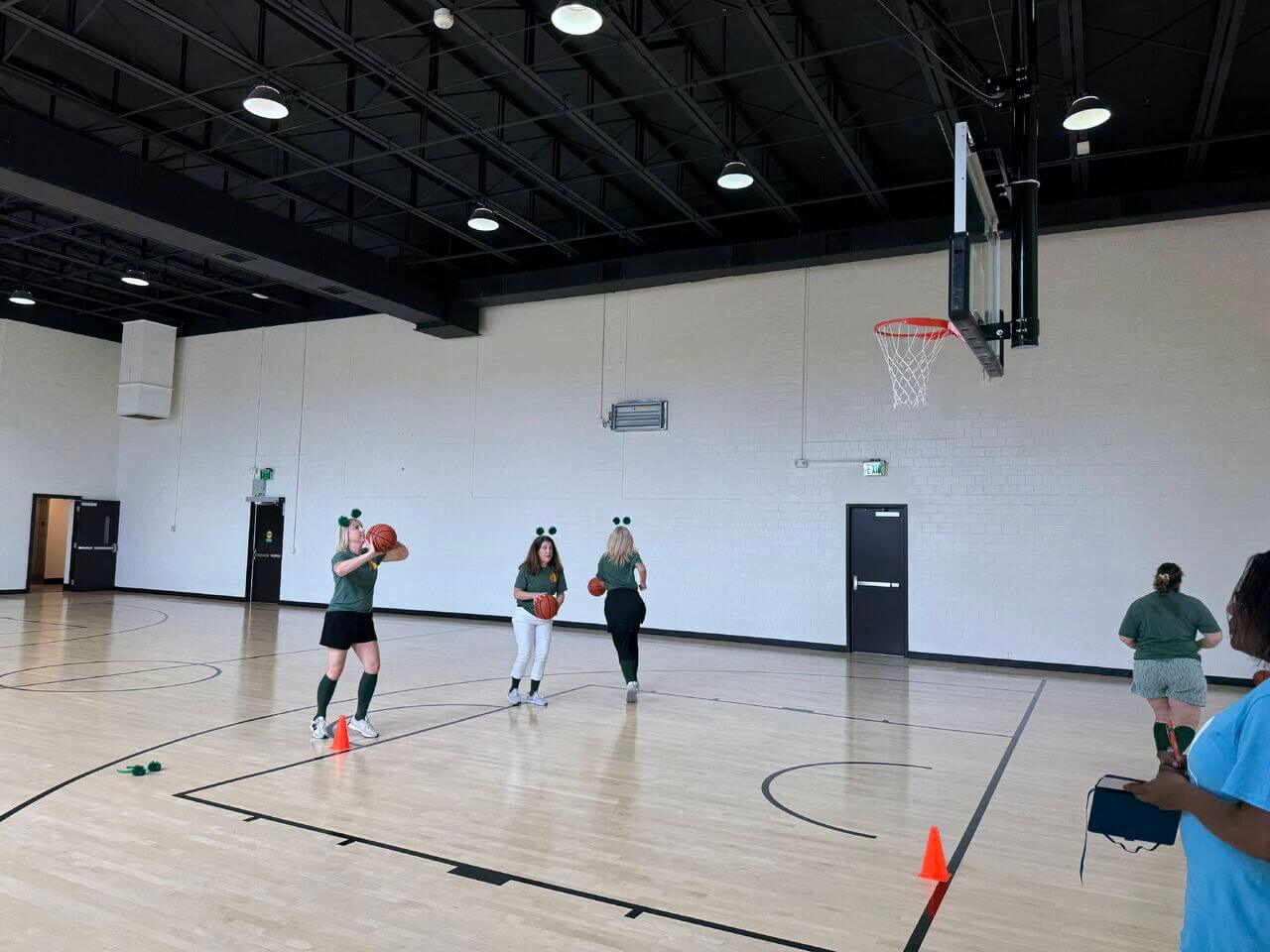 Women shooting baskets in a basketball activity for The Scurry.