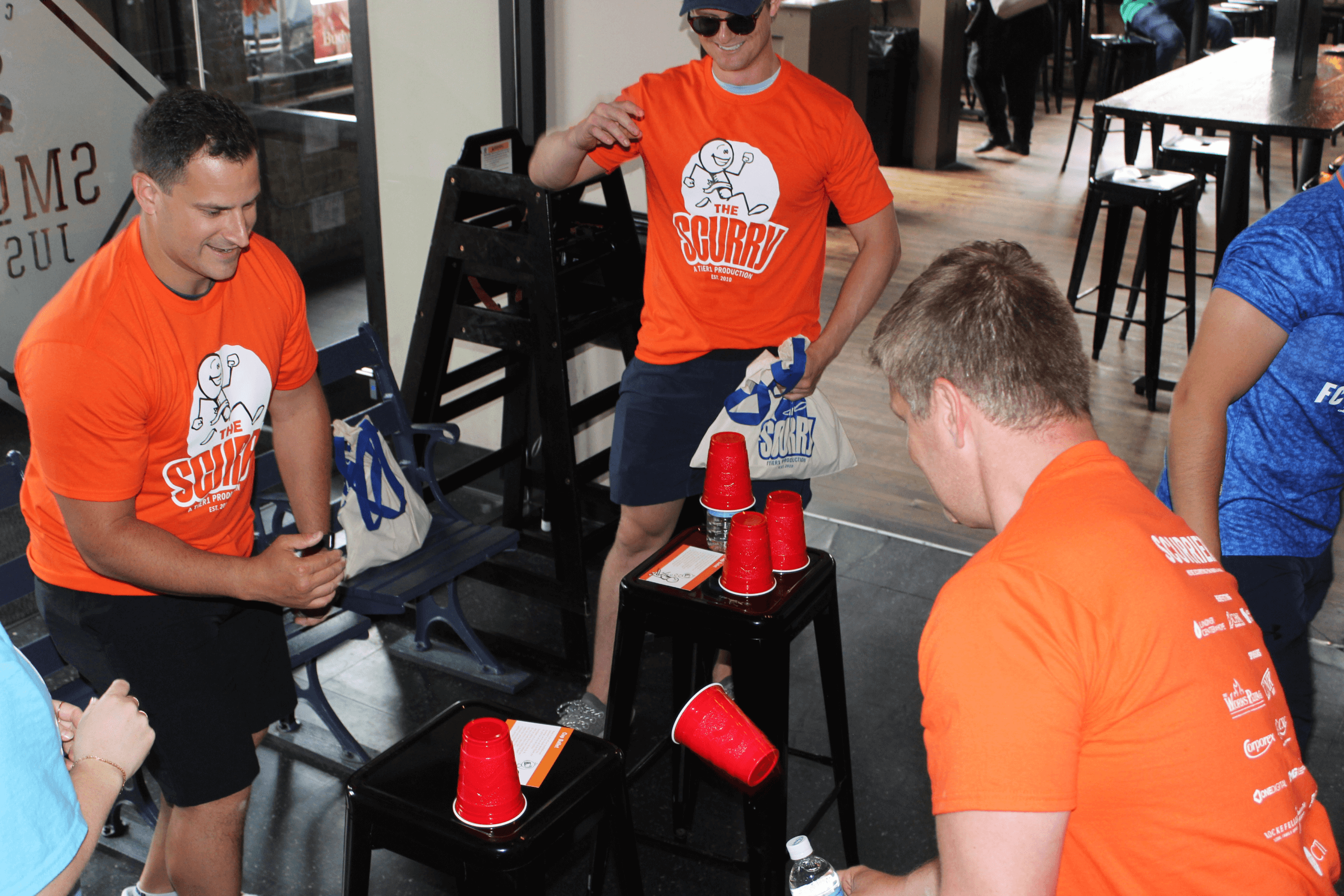 Two men trying to flip cups to land lip down.