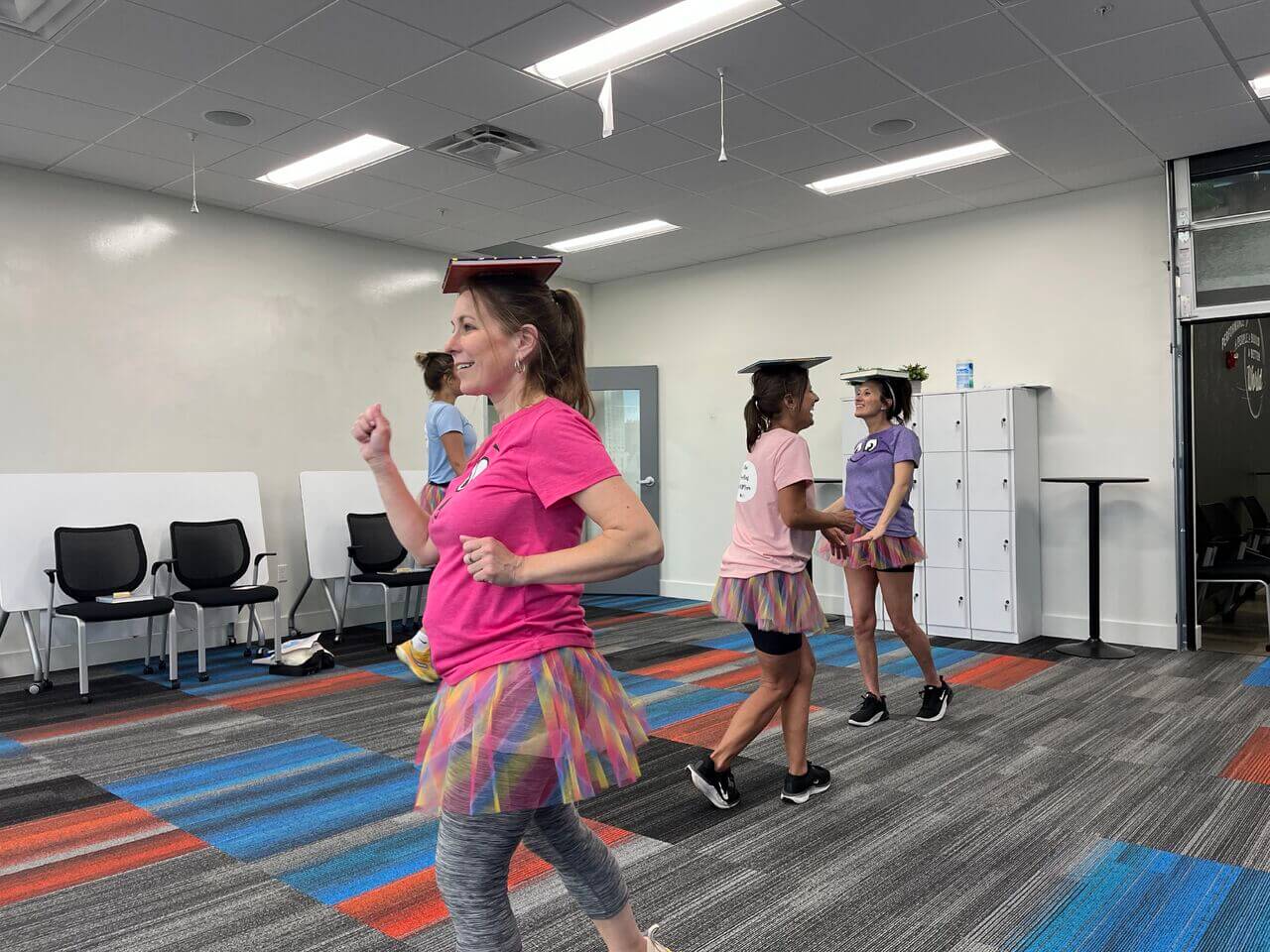 Women participating in an activity where they have to balance books on their heads.